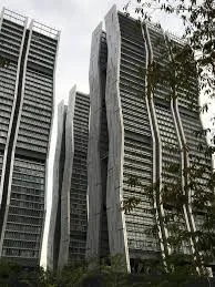 Exterior type: high-rise condominium; features: glass curtain wall, exposed concrete facade, twisting architectural design, recessed balconies, vertical fins, landscaped surroundings, urban context with greenery; style: modern.